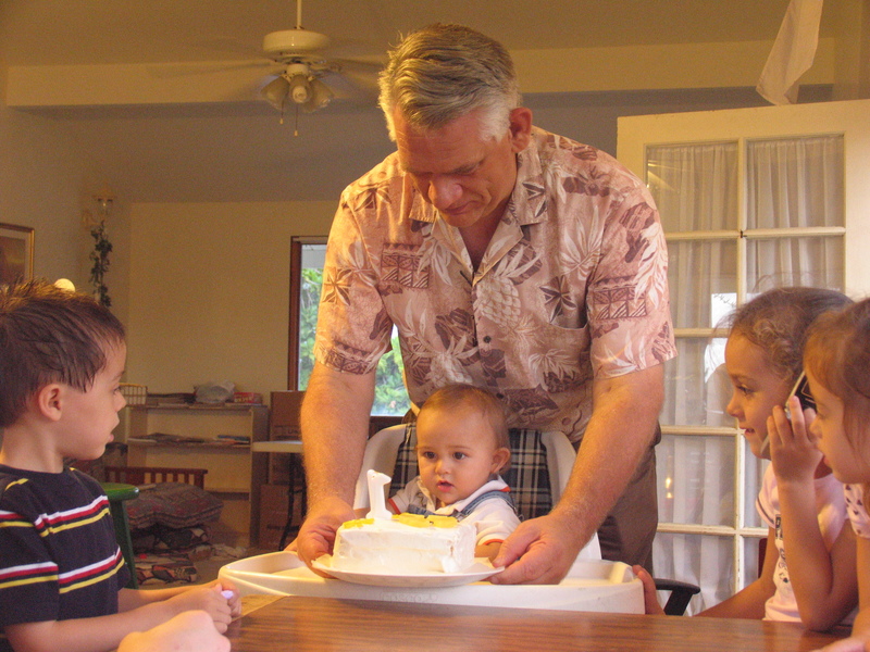 Grandpa helping Alex reach his cake.