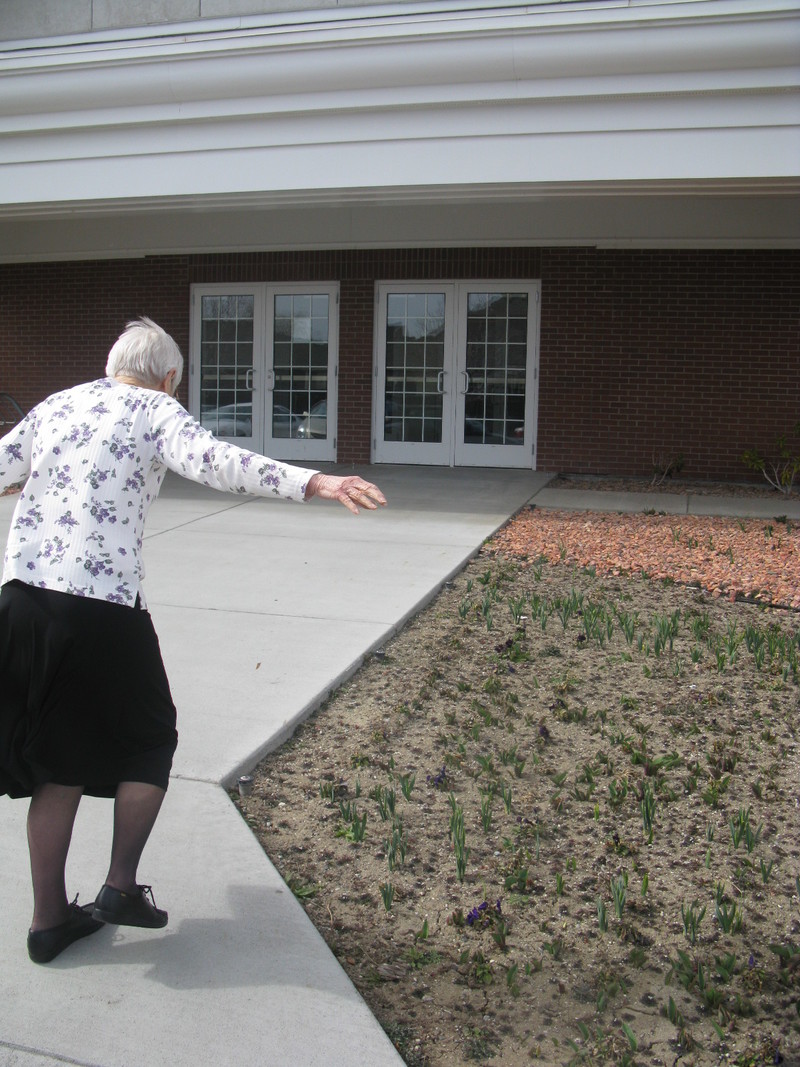 Mom prancing past the spring flowers.