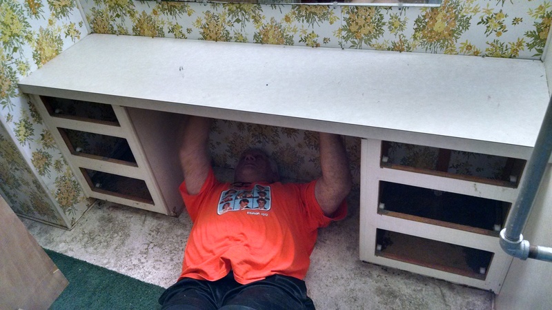 Don trying to take the hardware off the bottom of the Master Vanity.