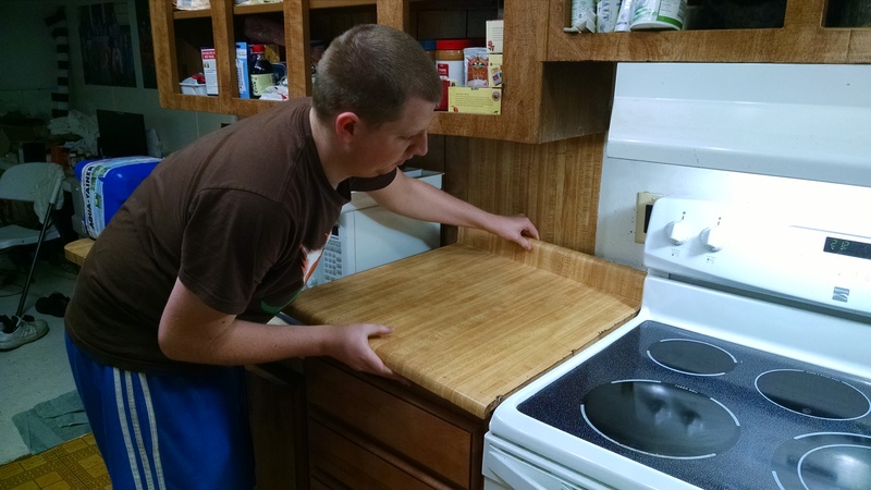 Isaac putting the old countertop on the new cabinet.