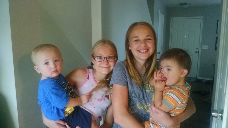 Austin and Calvin being held by cousins Briyanna and Hollie.