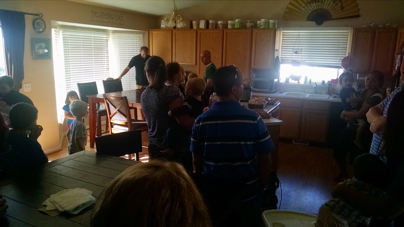 The family gathering in Larissa's kitchen for food.