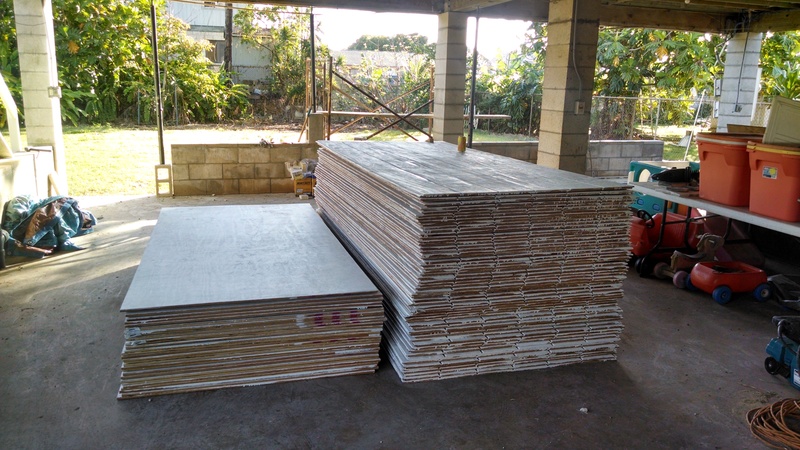 Two stacks of plywood. 30 sheets of regular ply on the left. 60 sheets of T1-11 on the right. Both are termite treated (borate) and painted with a primer coat. It's easier to paint before things are nailed to the second story of the house.