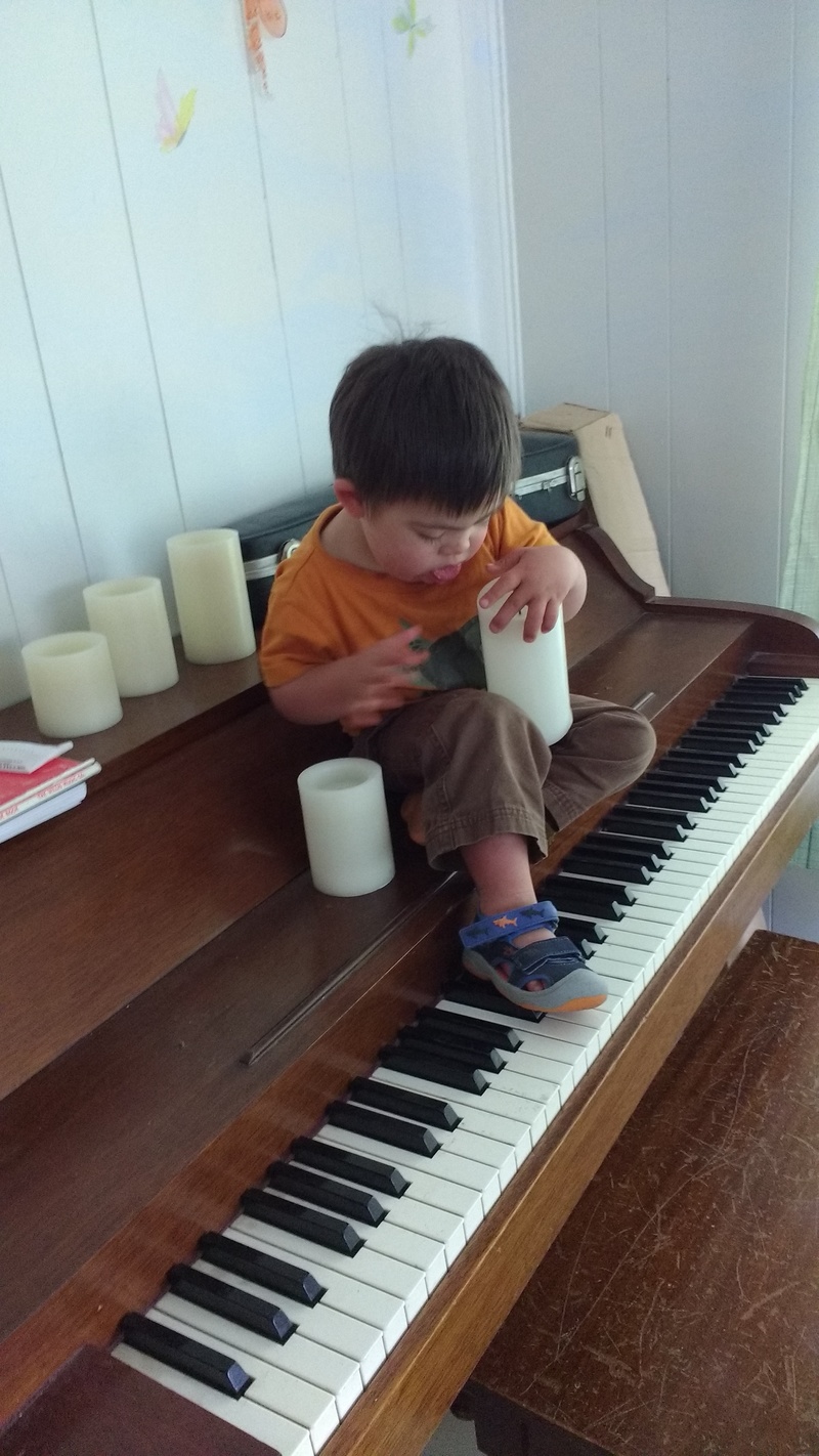 Calvin enjoys the candles and practices his organ footwork on the piano.