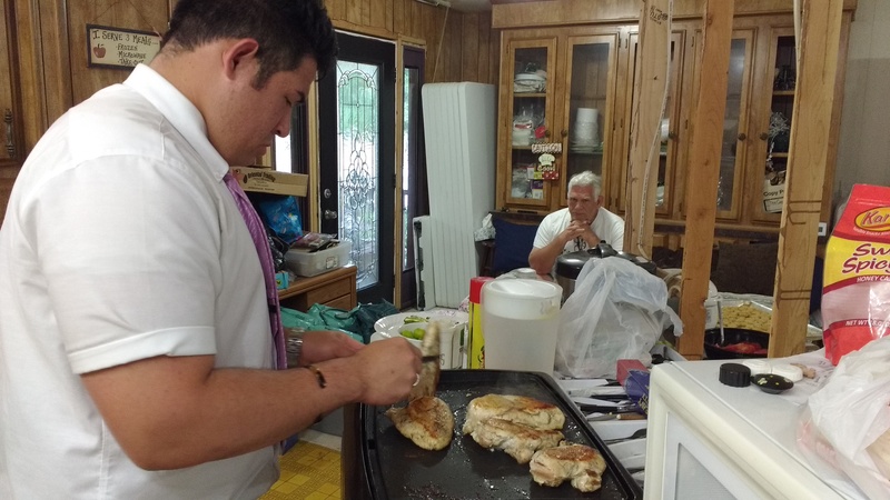 Elder Falatea cooking more of the chicken