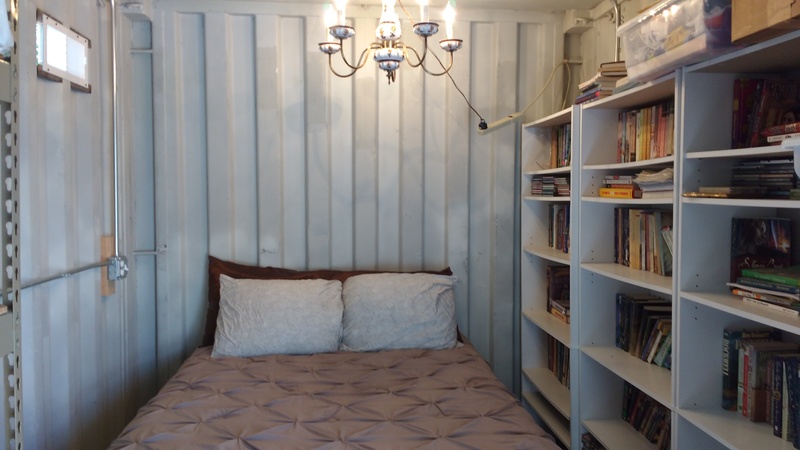 Redneck Elegance. A full-size bed in a shipping container, complete with chandelier and library.