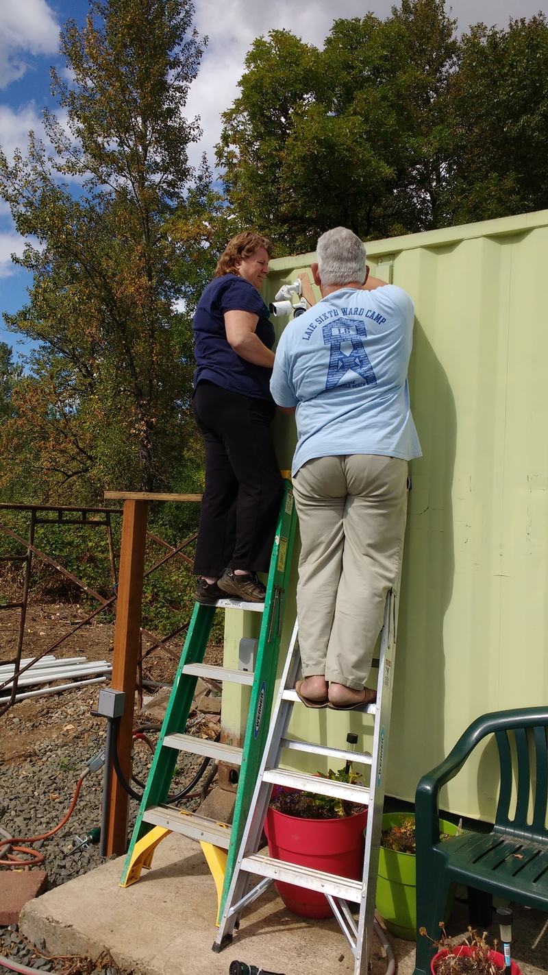 Lois and Don on ladders, installing the new Swann cameras.