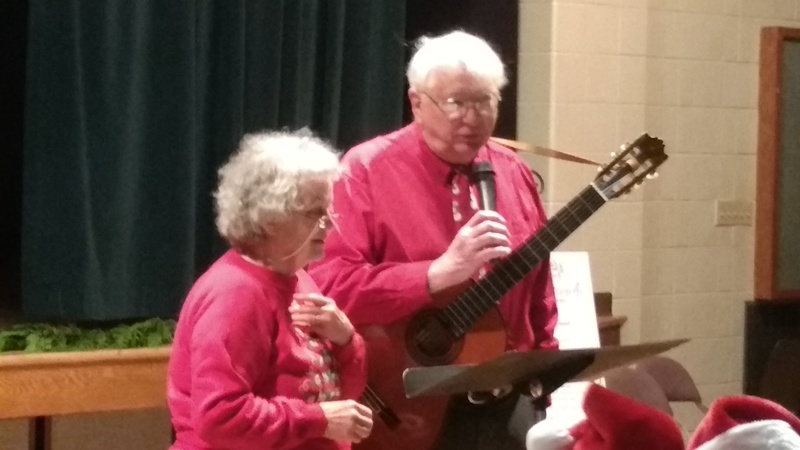 Singing carols, led by the Bob and Jeanne Wilson.