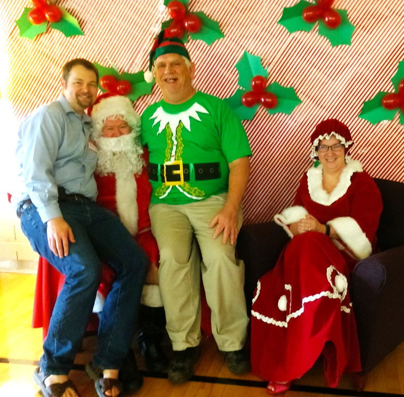 Don sits on the arm of Santa's chair.