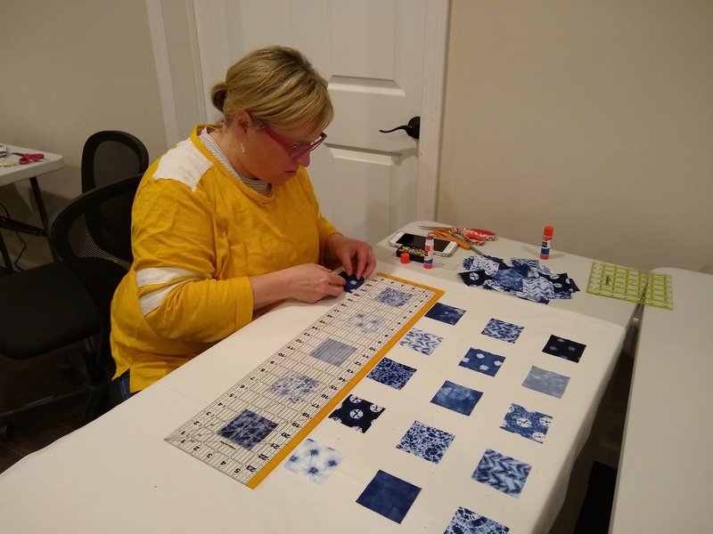 Kami gluing down her quilt pieces.